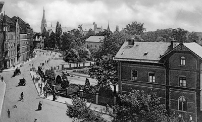 Die Lokalbahnstrecke durch die Kapellenstraße um 1910. Im Vordergrund rechts das Bahnhofsgebäude, in der Bildmitte die Kapelle des alten städtischen Friedhofs. <br />StadtAK 8/PBS oXIIIb 126
